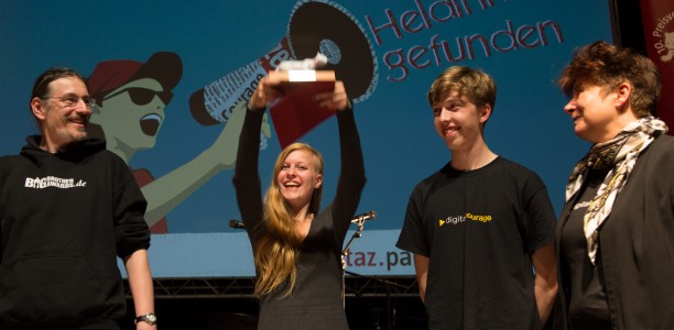 Der taz-panterpreis 2014 wird von den Gewinner.innen hochgehalten.