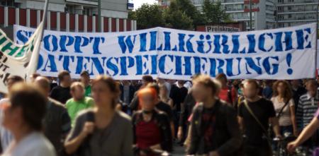 Demonstrant.innen mit einem riesigen Banner „Stoppt willkürliche Datenspeicherung“.