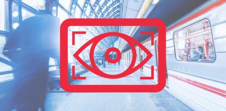 Ein Logo mit einem wachenden Auge, dahinter eine Bahnhofsszene mit einfahrendem Zug.