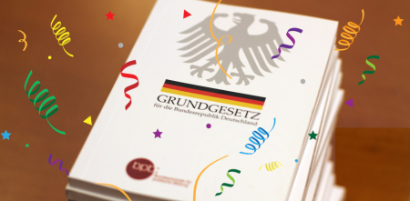 Ein stapel Grundgesetze mit Konfettigrafiken
