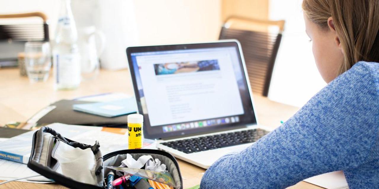 Mädchen macht Schulaufgaben am Laptop